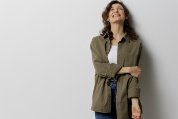 Cheerful happy smiling curly beautiful woman in casual khaki green shirt falling in love touches...