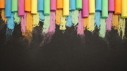 Multicolored chalk in row on black background. Education concept back to school. Copy space for your text. Banner - obrazy, fototapety, plakaty