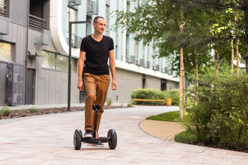 Man riding hoverboard, city. Guy on blue gyroboard
