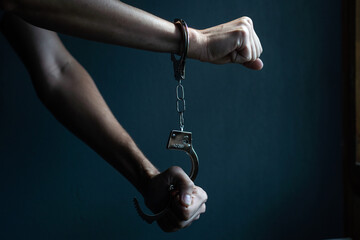 Obraz na płótnie Canvas male hands in handcuffs black background