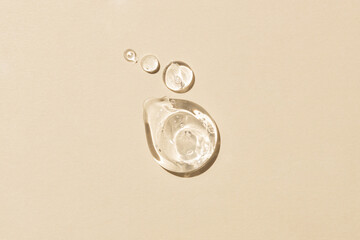 Glycerin gel texture. Transparent serum drop on beige background. Liquid gel moisturizer with bubbles macro