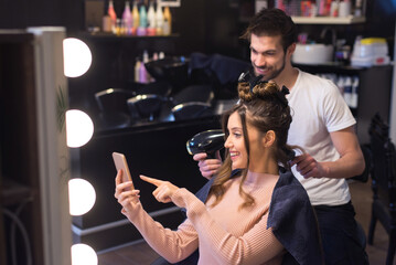 Young woman getting new hairstyle from hairdresser in the modern hair salon