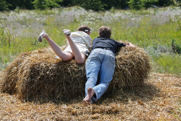 Naklejka na ściany i meble Couple at hay in sunny summer day