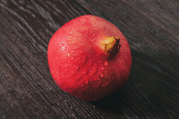 large red pomegranate on a wooden table