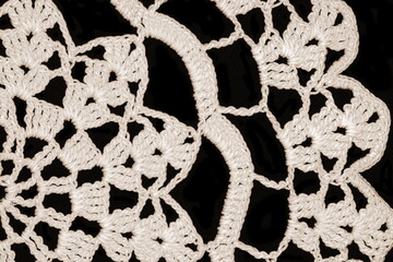 White crochet texture isolated on black background.