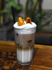 Honeycomb latte with coffee beans on wooden table