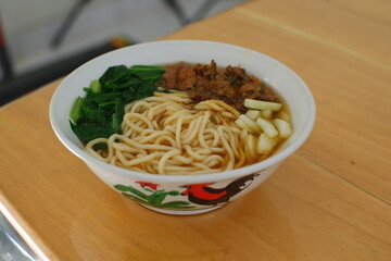 a bowl of chicken noodles