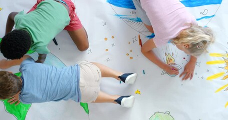 Children drawing, coloring and having fun on a colorful play mat from above. Small diverse kids and their friends on a white canvas, spending time at a preschool being creative during art class
