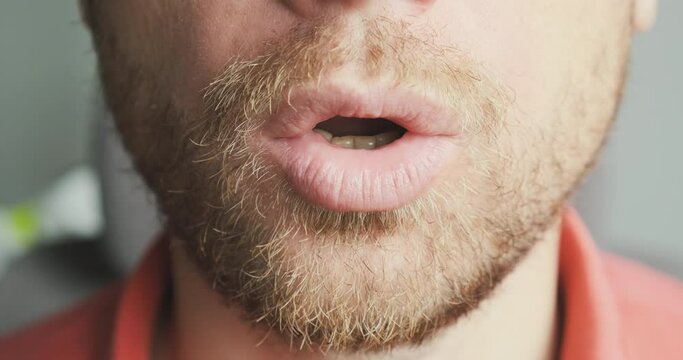 Face of an unshaven man exhales air through his mouth. Close-up, portrait, unrecognizable. Calm concept, breathing practice, nerves, health, relaxation.