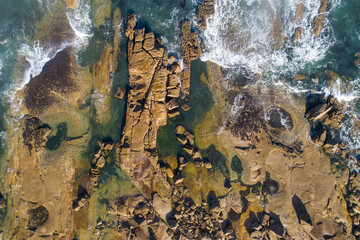zenithal aerial view of a rocky coastline at dawn