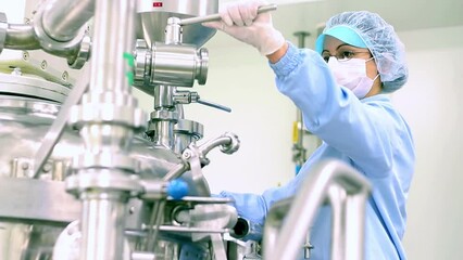 Pharmaceutical Research And Development Of New Medicines. Female Worker In Protective Workwear Working In Controlled Area - Sterile Pharmaceutical Manufacturing.