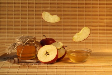 Red fresh apples with honey on wooden background