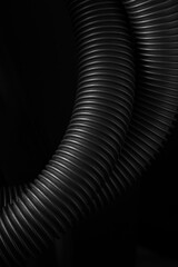 Close up capture of vacuum cleaner hose on black background abstract