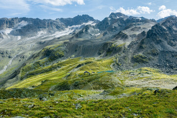 Green landscape of the swiss mountains with a lake and a shelter