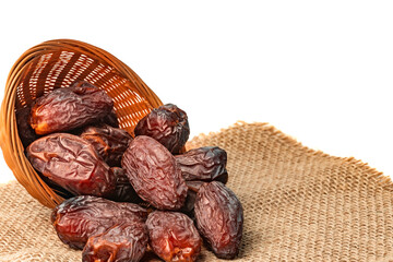 Royal dates in a basket on burlap isolated on white background. Copy space.