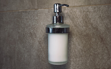 Fototapeta na wymiar soap on the bathroom wall. push button liquid soap. shower gel and soap