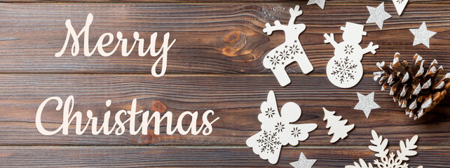 Merry Christmas text. Top view of Banner Christmas decorations and toys on wooden background. Copy space. Empty place for your design. New Year concept