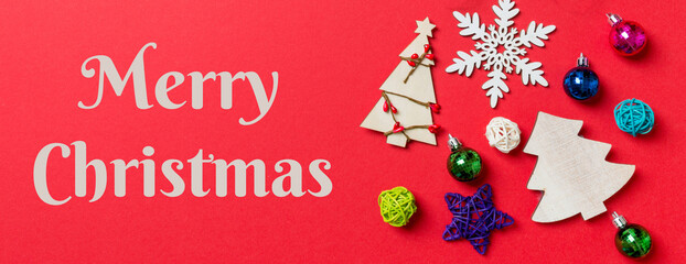 Merry Christmas text. Top view Banner of holiday decorations and toys on red background. Christmas ornament concept with empty space for your design