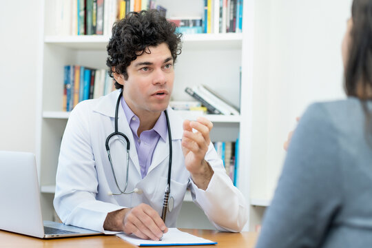 Junger Arzt spricht mit einer Patientin