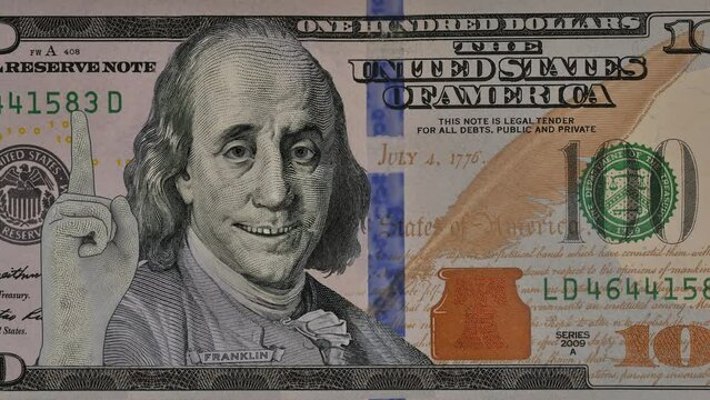 Benjamin Franklin shows on a hundred dollar bill, advertises something, pointing at it with his hand and eyes. Includes a green screen version for easy background clipping.