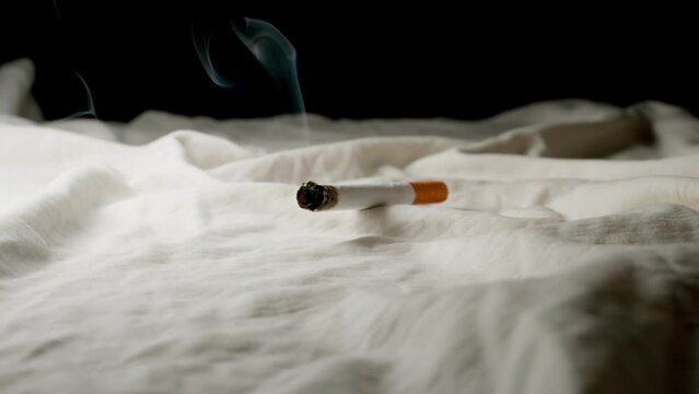 SLOW: Cigarette smoking on a bed at home
