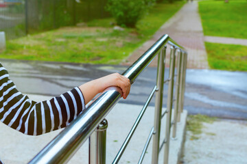 A child's hand is holding onto the railing