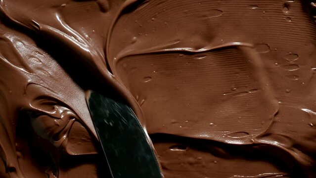 TOP VIEW: Knife spreads a chocolate paste