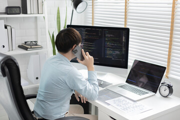 Professional development programmers are talking on the phone with their colleagues for website planning or programming on computers, Write information or code for website,  HTML, javascript, Software