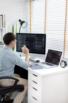 Professional development programmers are sipping coffee in a private office, Working on coding or programming on a computer, Write information or code for the website,  HTML, Javascript, Software.