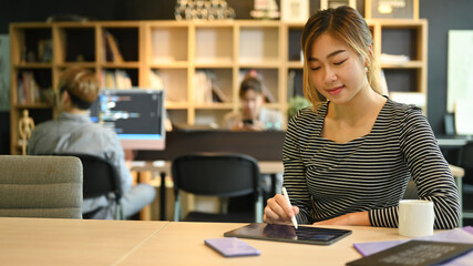 Young programmers or software developers using digital tablet, working in modern office