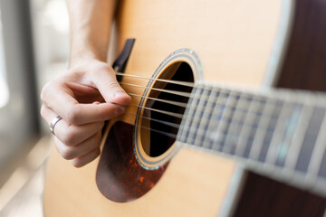 Fototapeta premium Male hand playing acoustic guitar.guitar play. Close up of guitarist hand holding guitar pick