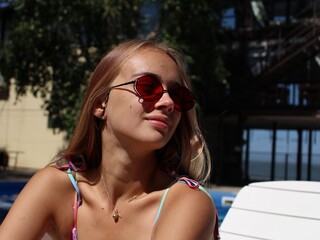 attractive and sexy girl with a beautiful ass in a bikini is relaxing by the pool