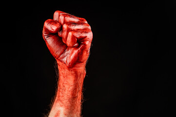 Bloody male fist on a black background. Copy space. 