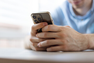 Man with a finger on the screen using a mobile phone in the office.
