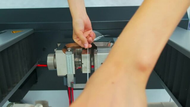 Polymer thread for plastic sack bags is tested for strength in laboratory, slow motion