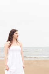 Fototapeta na wymiar young woman in a white dress on the beach