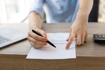 Front view of employer pointing to a contract where to sign. .