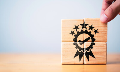 Businessman holding wooden cube block which print screen the best quality assurance with five stars...