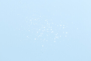Sparkling silver glitter on blue background. Holiday blurred lights