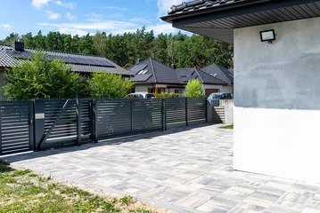 Fotobehang A modern panel fence in anthracite color, a visible sliding gate to the garage and a wicket with a letterbox. © Michal
