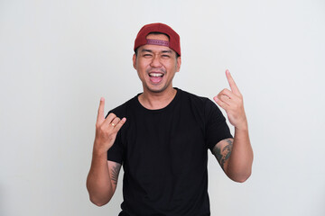 Tattooed asian man wearing plain black tshirt showing rock and roll pose