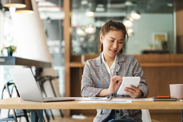 Business women using calculator at working with financial report.