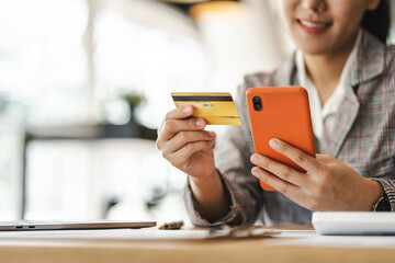 Young Asian woman using credit card and mobile phone for online shopping, technology money wallet...
