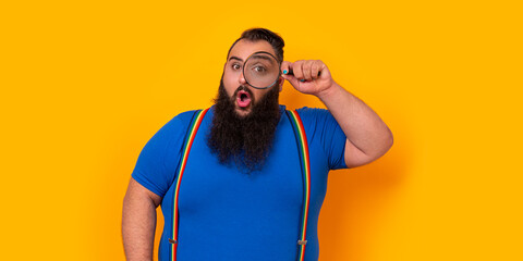 Big bearded funny man with a magnifying lens, big eye and a surprise expression	