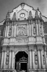 Architectural Detail of the old restored Basilica of Our Lady of Guadalupe, Mexico City, Central Mexico - Facade view in BW with double columns, stone carvings and niches with saint statues.