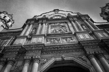 Architectural Detail in BW of the old restored Basilica of Our Lady of Guadalupe in Mexico City, Central Mexico -Facade view with double columns, stone carvings and niches with saint statues.