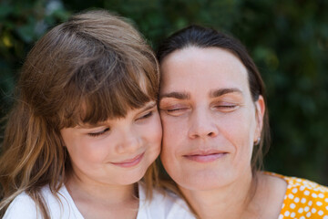 Fototapeta premium portrait of mother and little daughter in nature on a summer day. Happy family