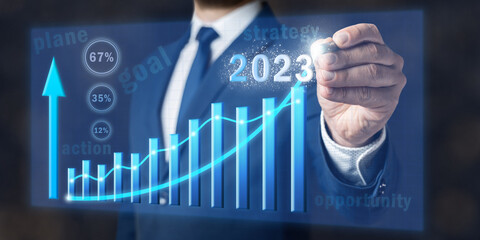 Concept of increase business in 2023 year, businessman draws graph, planning new strategy of growth, goals and opportunities, virtual screen