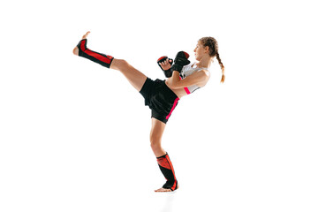 Portrait of sportive girl, junior MMA fighter in sports uniform training isolated on white...
