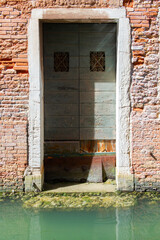 Door, obsolete wall and canal. Venice - ancient beautiful romantic and tourist attraction italian city